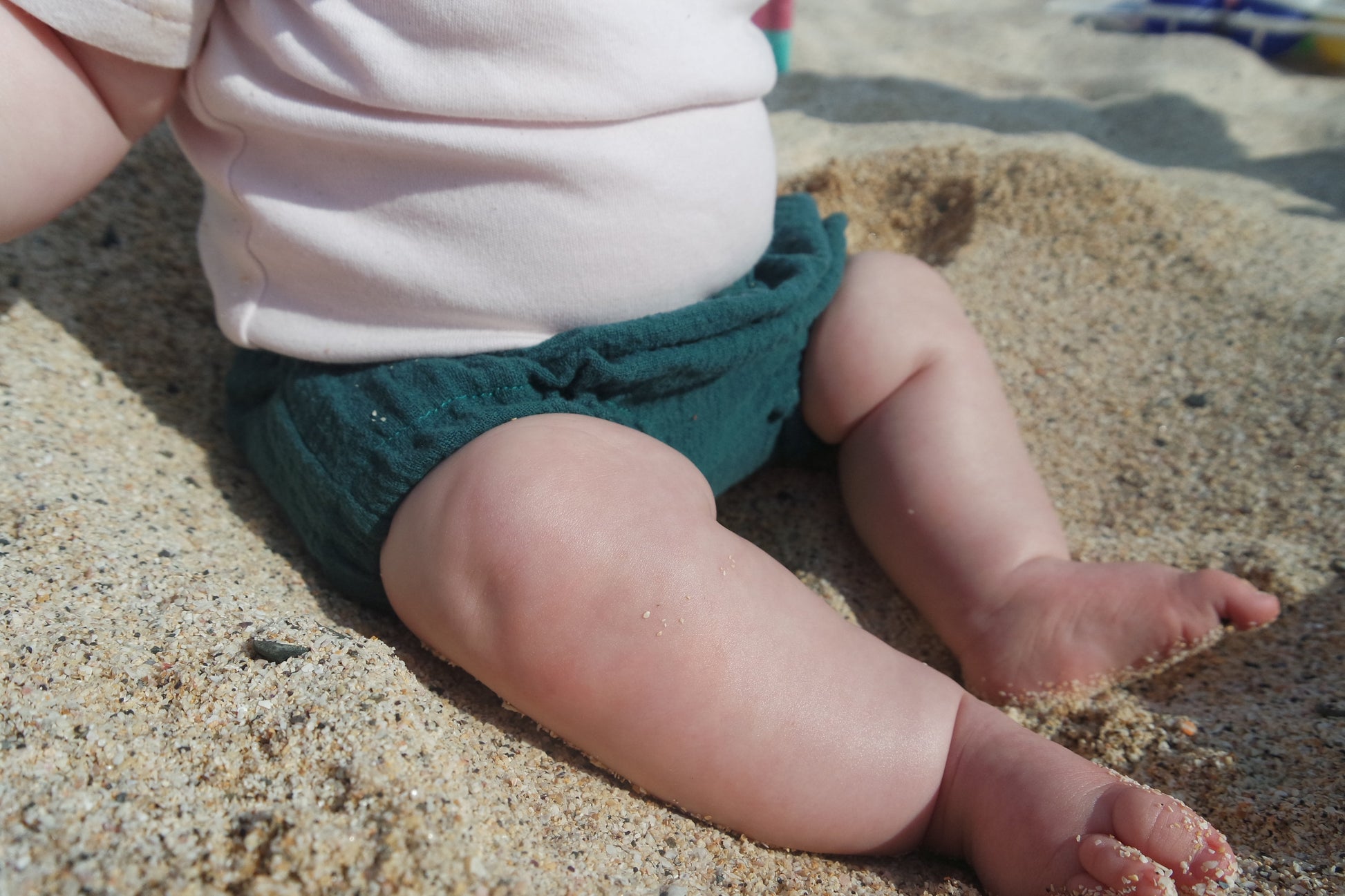 baby girl wearing handmade bloomers nappy cover diaper cover sat on the sand beach unisex bohemian style hippy