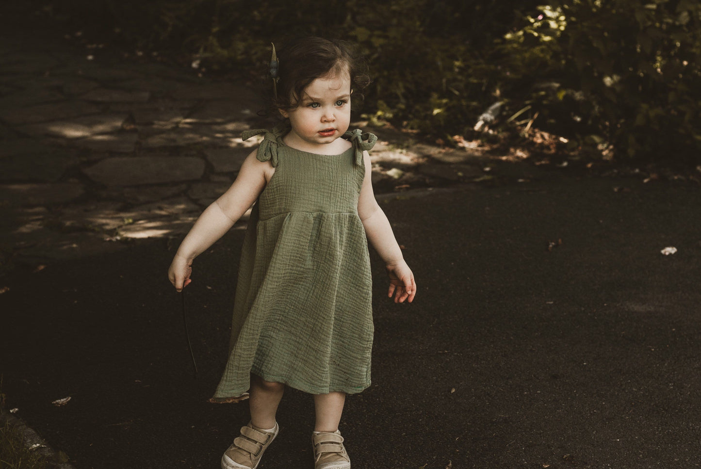 girl stood in garden in summer wearing a double gauze dress in forest green adjustable straps sustainable bohemian hippy beach clothing